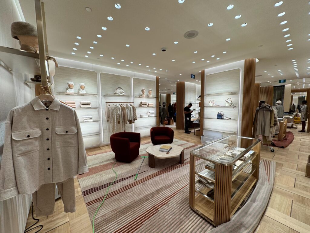 Boutique interior with display cases, wall shelving and lounge chairs
