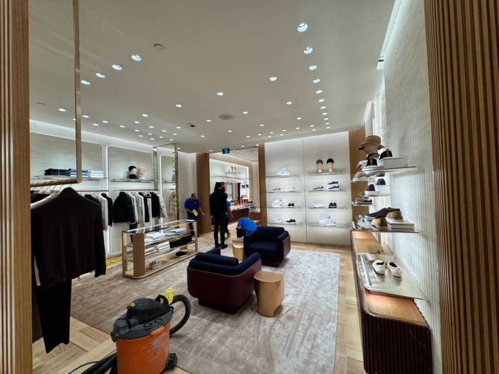 Boutique sales floor with wood slat columns and a seating area near completion