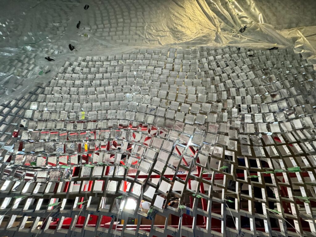Faceted mirrored tile feature surface partly installed