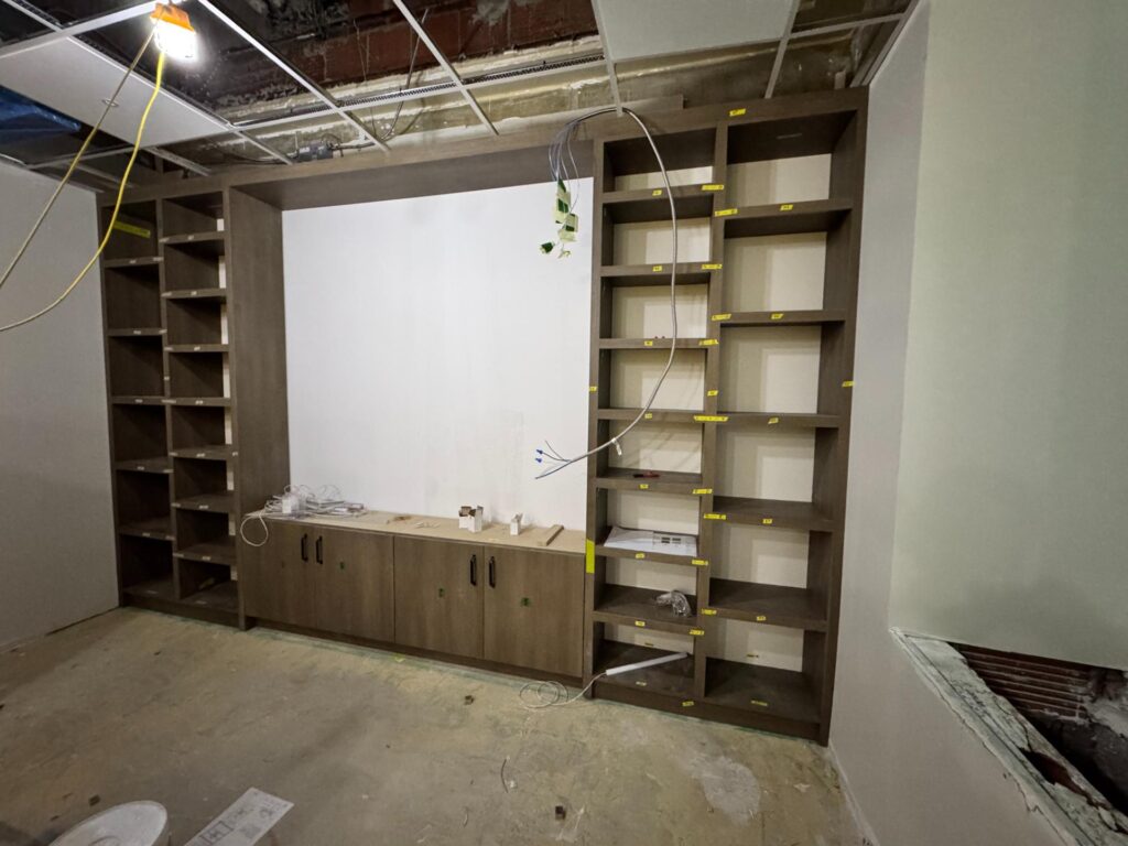 Built-in shelving and base cabinets framing a wall during installation
