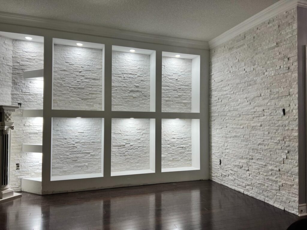 White stacked-stone feature wall with lit recessed niches